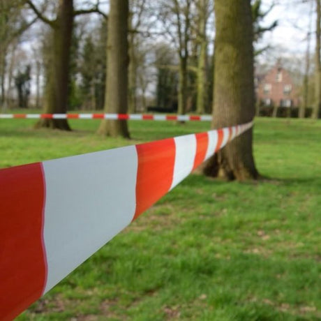 Rol van rood-wit afzetlint, gebruikt voor het afbakenen van gevaarlijke zones.